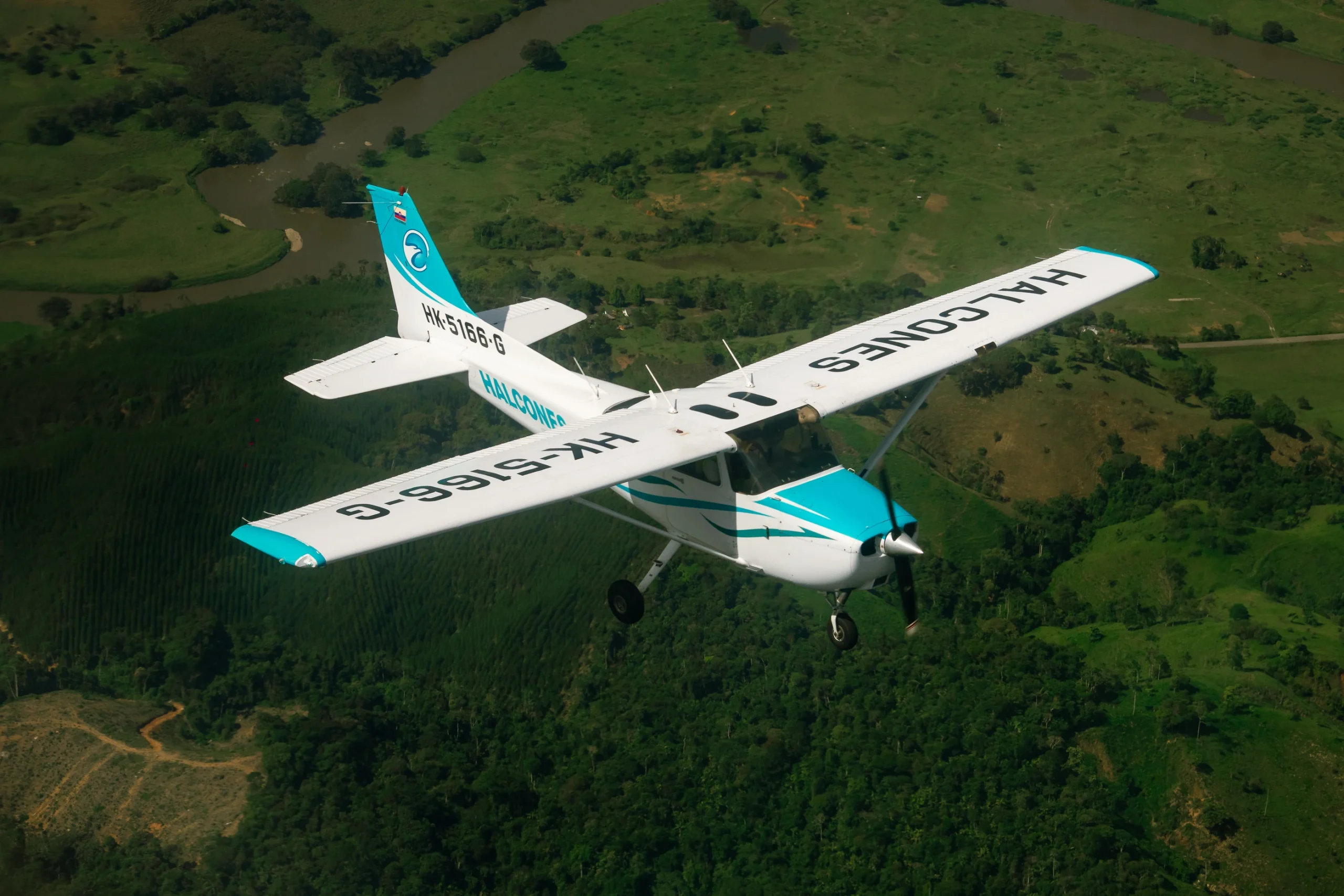 Avión de entrenamiento de Halcones Aviation School en vuelo, utilizado en la formación de pilotos comerciales en Colombia.